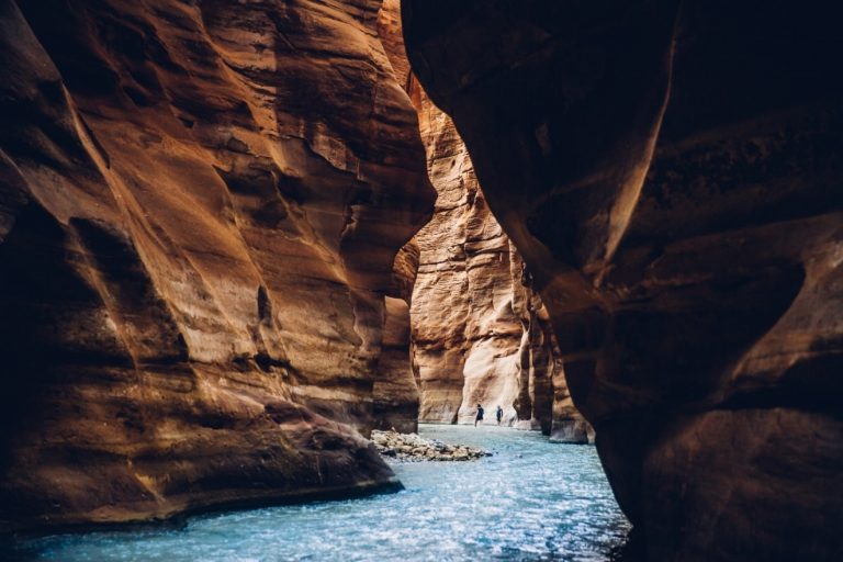 Hikers in the narrow sandstone canyon of the Wadi Mujib Siq Trail, Jordan